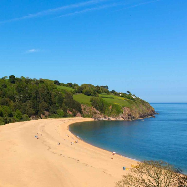 A view across the golden sands of a Devon beach - visiting the beach is one of my top things to do with kids in Devon