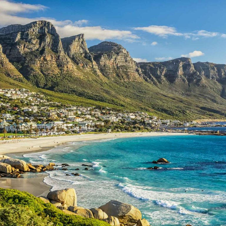 View of the beach and mountains of Cape Town, with houses scattered along the slope between hills and sea - one of my favourite places to visit in South Africa with children