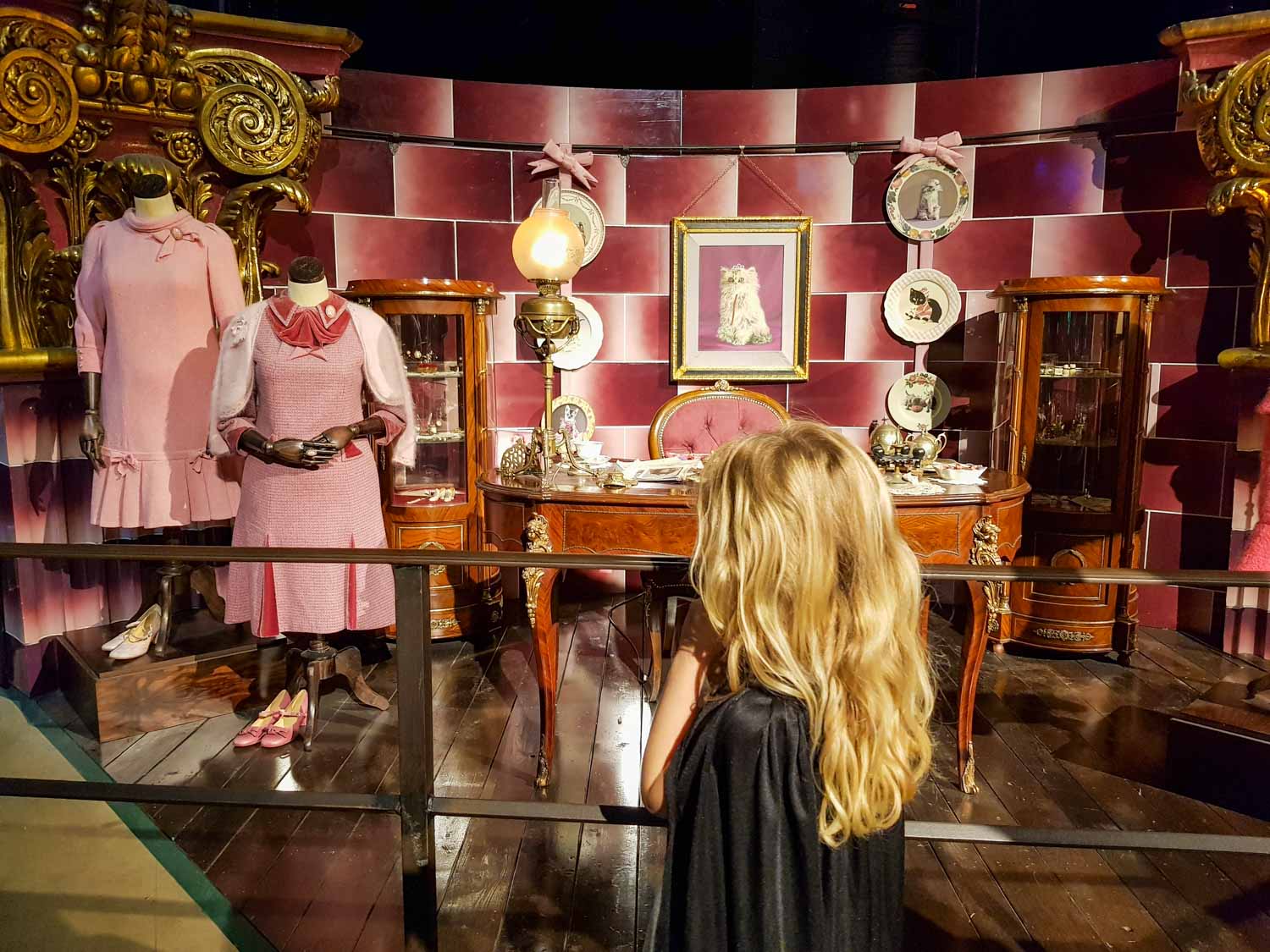 My daughter looks at exhibits from the Dark Arts section including Dolores Umbridge's clothes and desk - my tips for the Harry Potter tour, London
