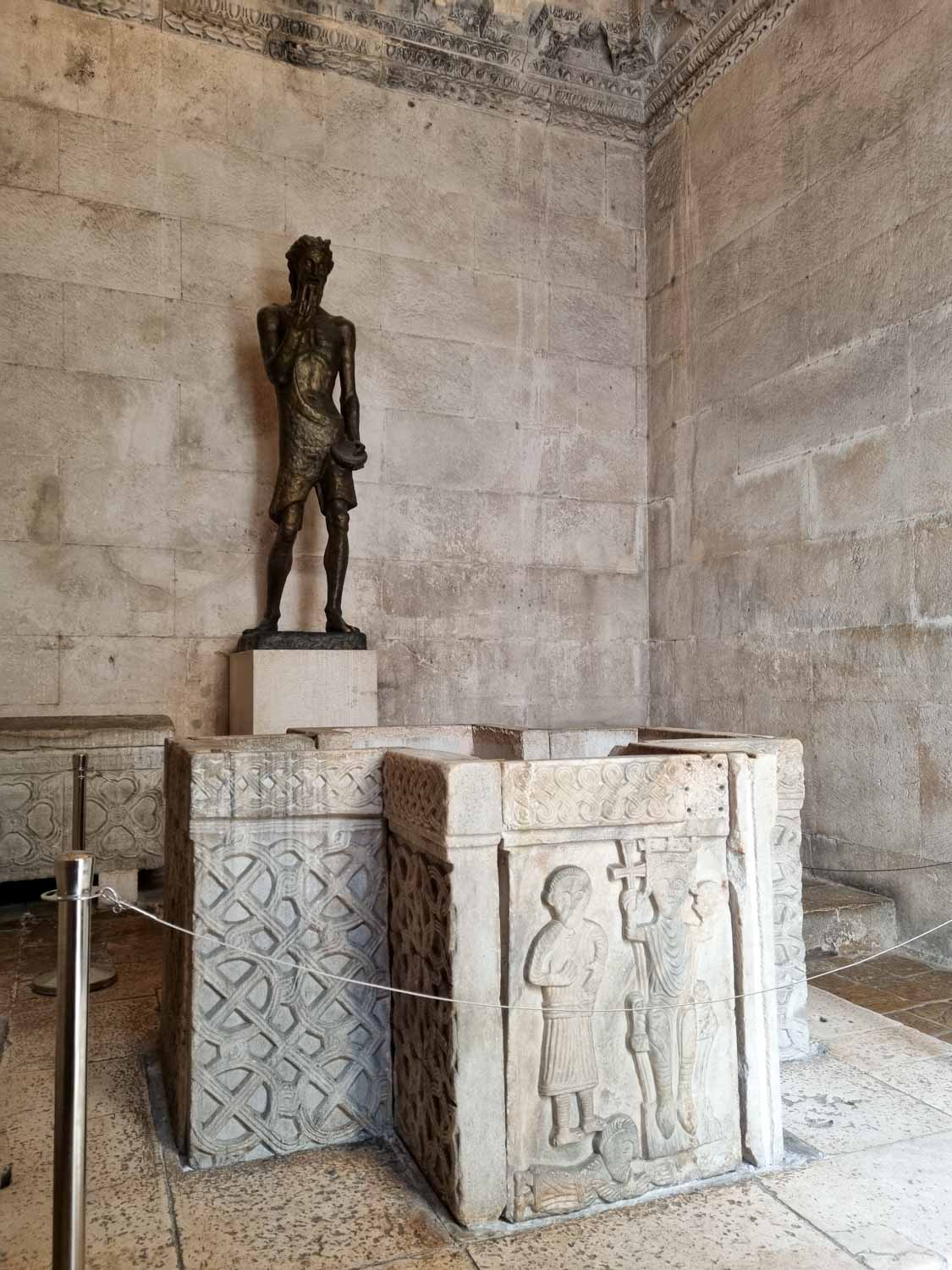 Statue and stone tombs inside the Baptistery of Split, formerly the Temple of Jupiter - one of the main Roman sites to see in Split with kids