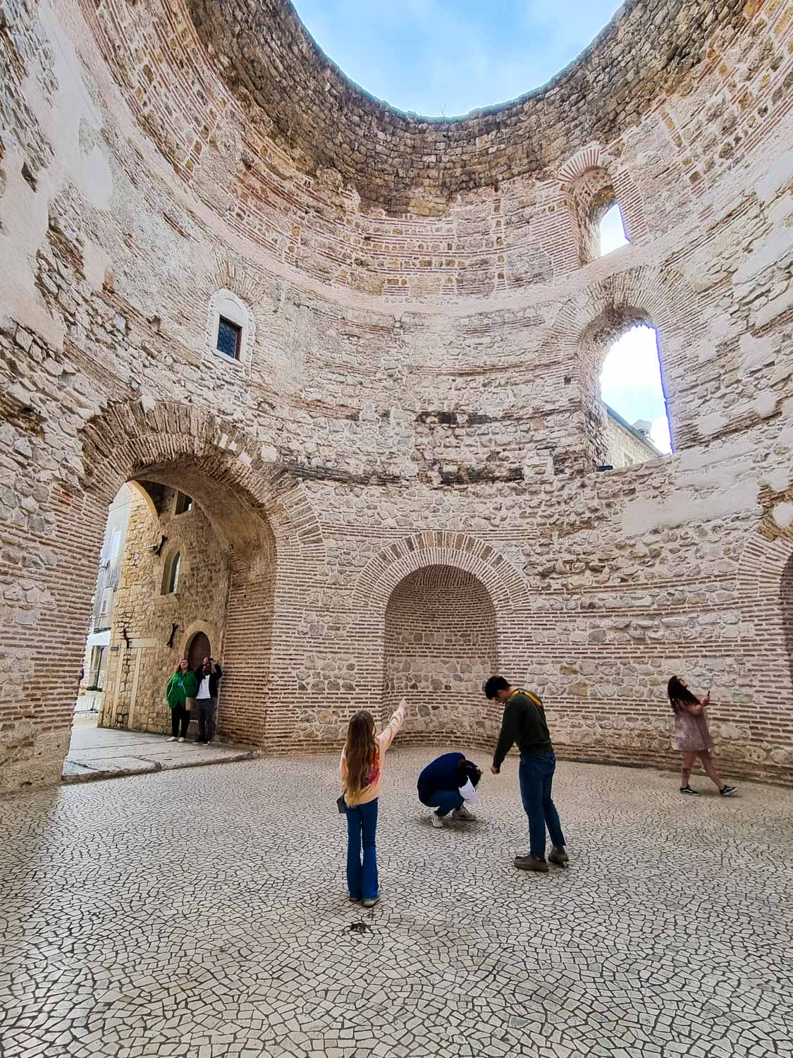 My daughter points up to the hole in the roof of the Vestibule, part of Diocletian's Palace and one of the best places to visit in Split with kids