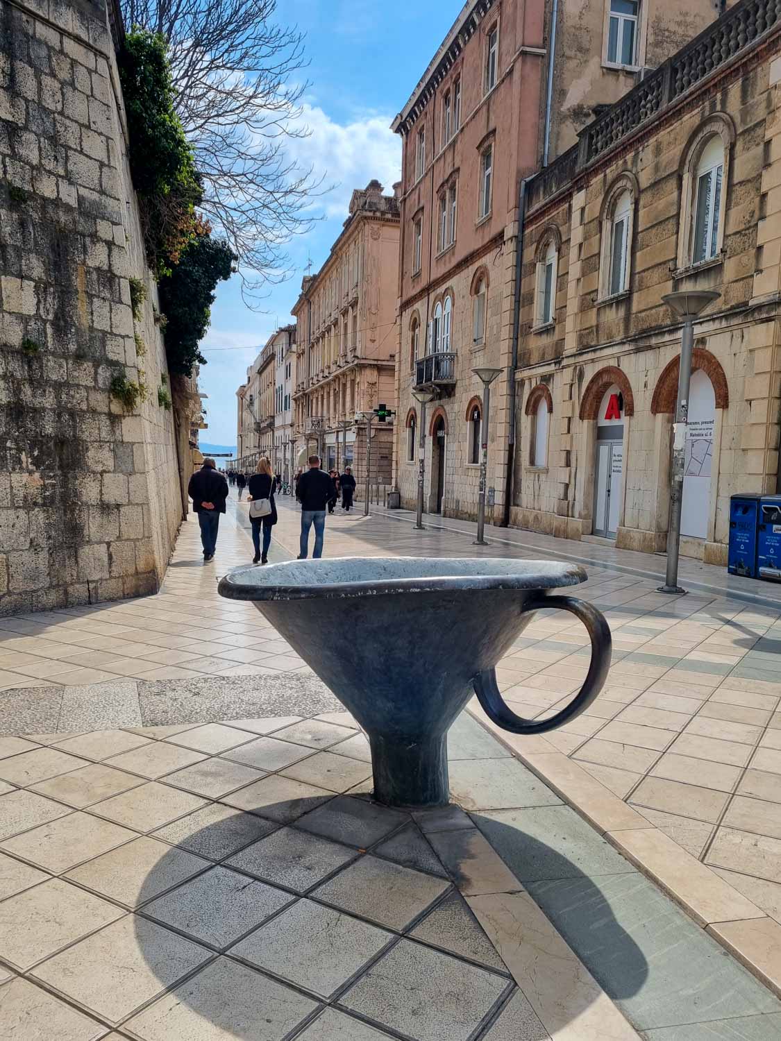 View of a piece of street art shaped like a huge cup in one of the side streets of Split - wandering the streets is one of the best things to do with kids in Split