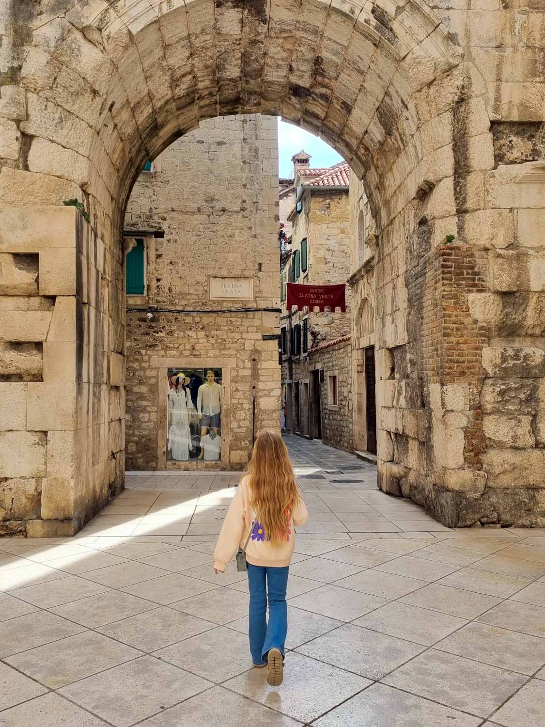 My daughter walks towards the golden gate of Diocletian's Palace in Split - a walk through the old streets is one of the best things to do in Split with kids