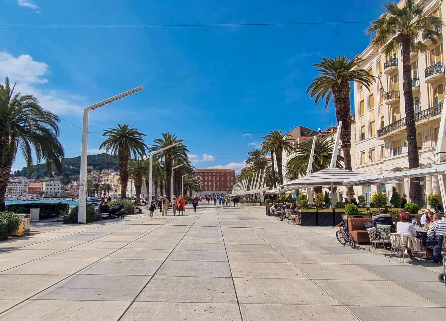 View along the Riva waterfront promenade lined with palm trees and cafes - a walk here is one of the best things to do in Split with kids