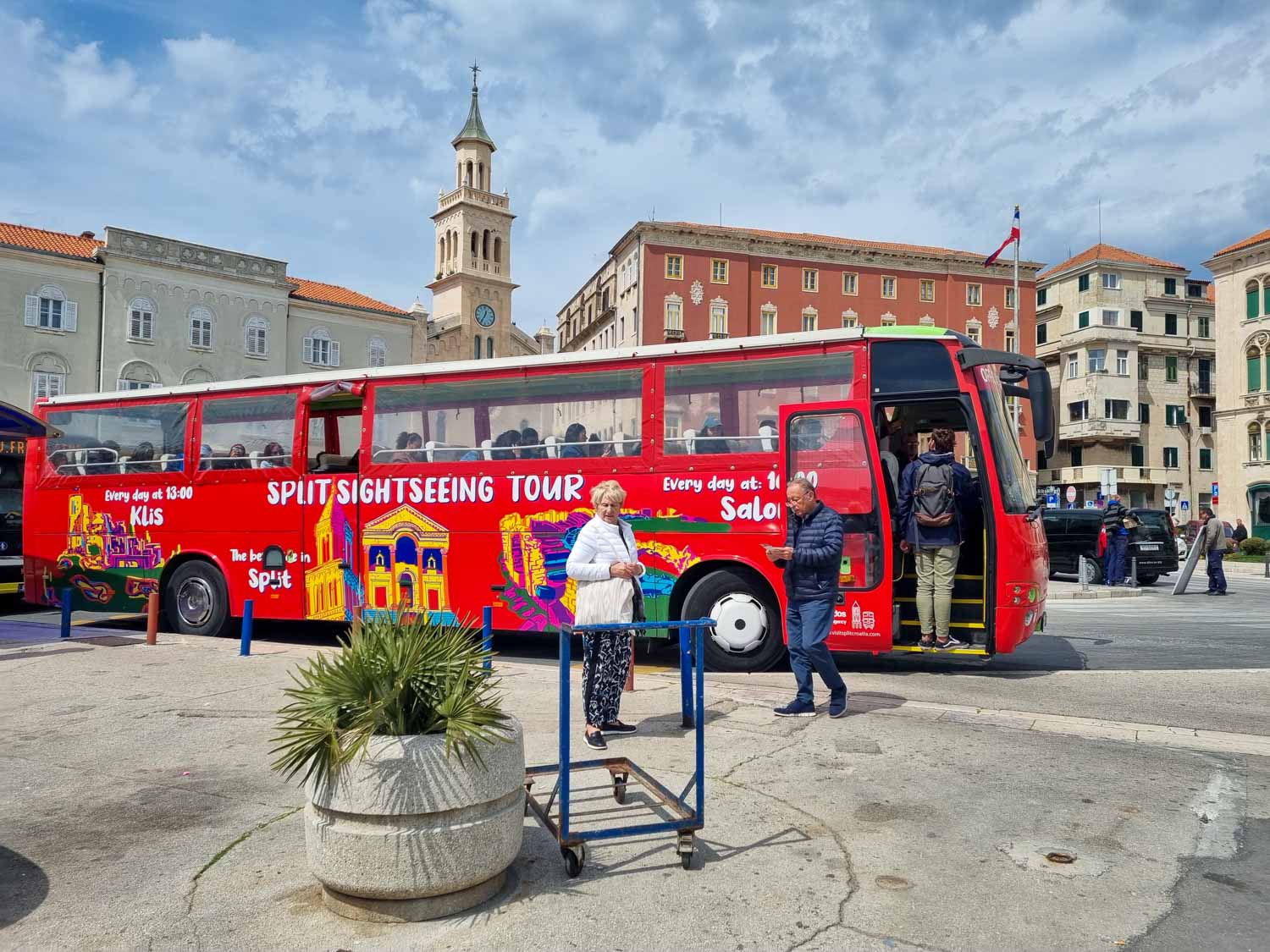 Red Split Sightseeing tour bus parked at the end of the Riva - the open-top bus and daily tours are a great way to explore Split with kids