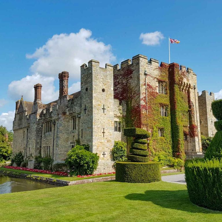 A view of Hever Castle, Kent from the grounds against a blue sky - one of the best castles in Kent with kids