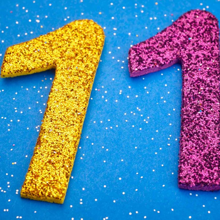 Sparkly figure 11 in yellow and purple against a blue background - looking back at 11 years of travel with a child