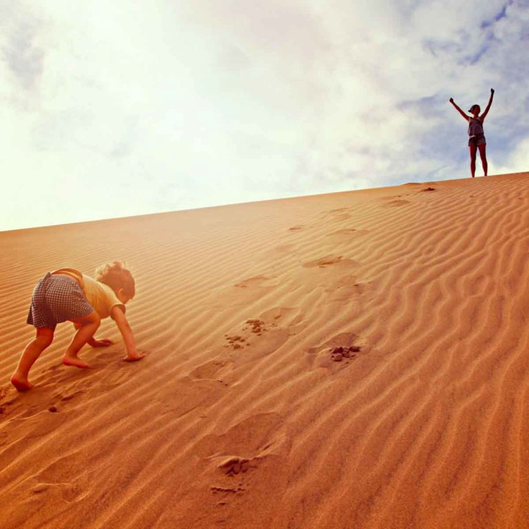 Child climbing the dunes at Maspalomas in Gran Canaria - one of my top things to do in Gran Canaria with kids