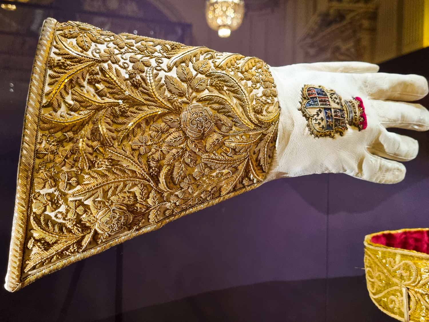 Richly embroidered gold and white Coronation glove on display in a special exhibition as part of the summer opening of the state rooms at Buckingham Palace - my tips for visiting Buckingham Palace in 2023