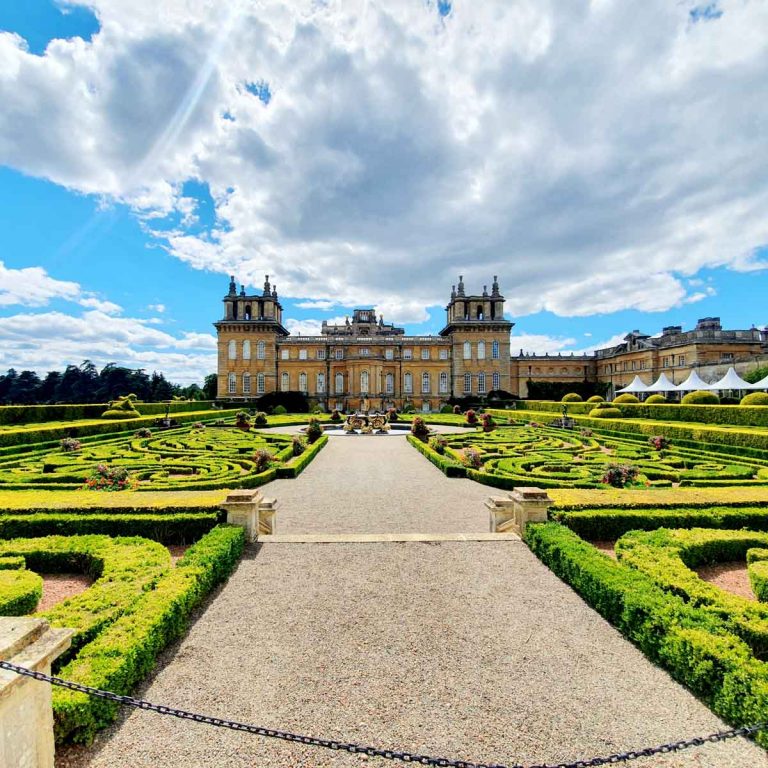 View of Blenheim Palace seen from across the formal gardens on a sunny day - my review of visiting Blenheim Palace with kids