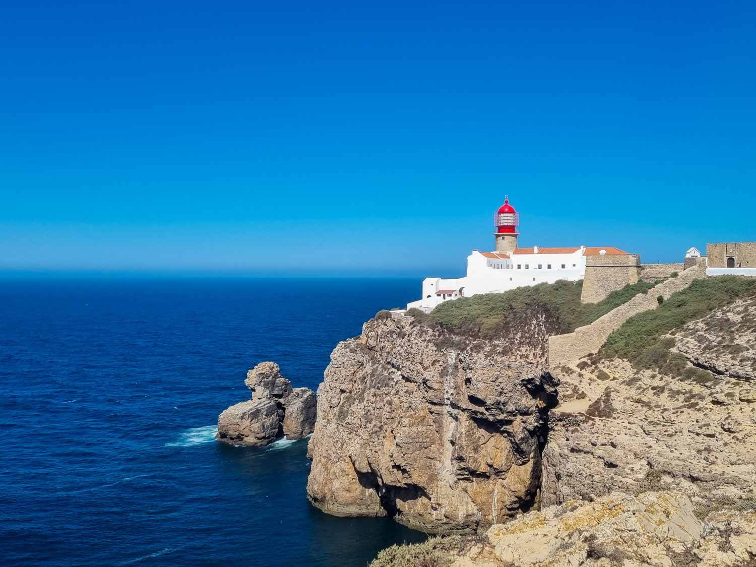 View towards the white building and red tower of the lighthouse at Cabo de Sao Vicente, the most south-westerly point of mainland Europe - the end of the world is a great day out from Lagos for families