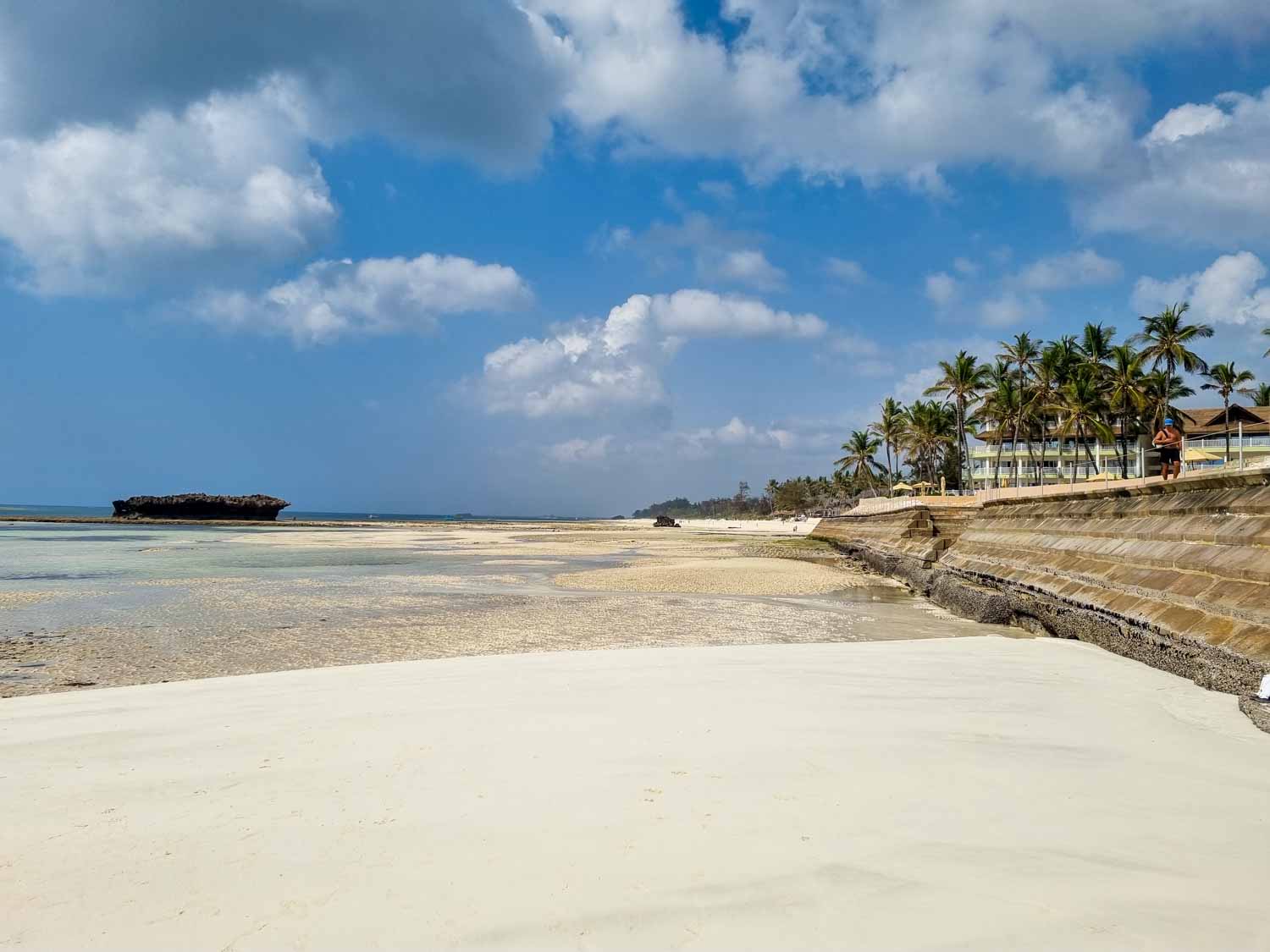 View along the white sand beach to palm trees and some of the buildings of Hemingways Watamu - my review of Hemingways Watamu with kids