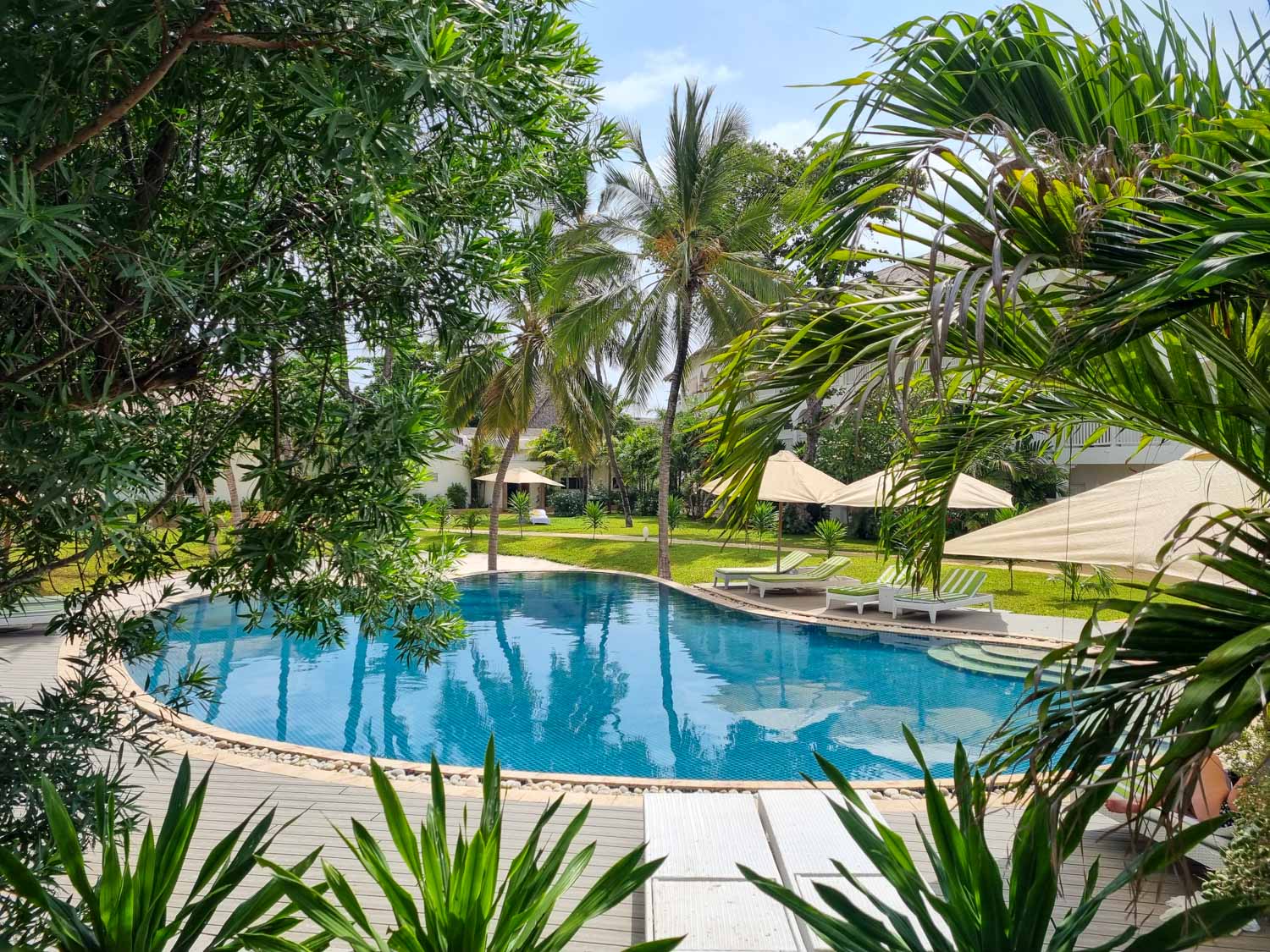 View through the trees to the quiet pool at Hemingways Watamu in Kenya - my review of Hemingways Watamu with kids