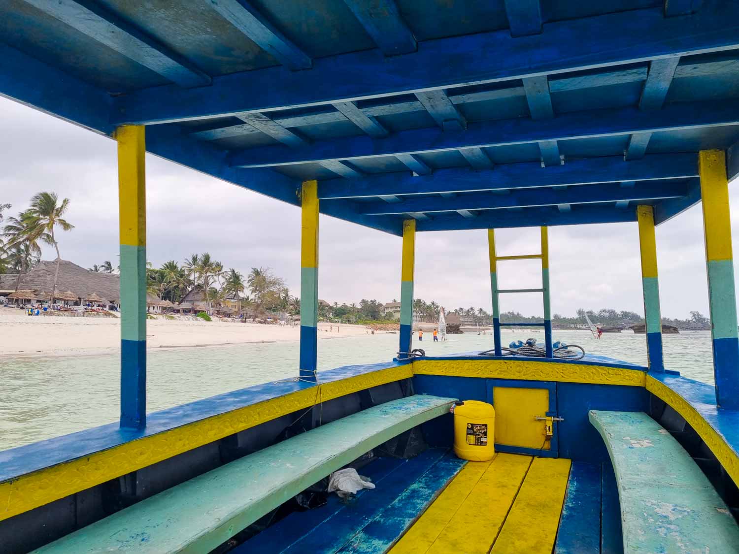 Blue, yellow and turquoise painted small boat, one of the local boats running tours to spot dolphins and snorkel the national marine reserve which we took during our stay at Hemingways Watamu with kids