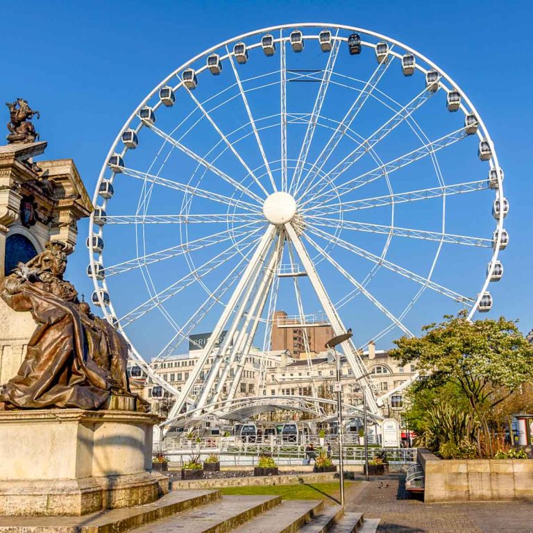 Piccadilly Gardens in Manchester city centre, with a view of the ferris wheel - the best things to do in Manchester with kids on a family city break