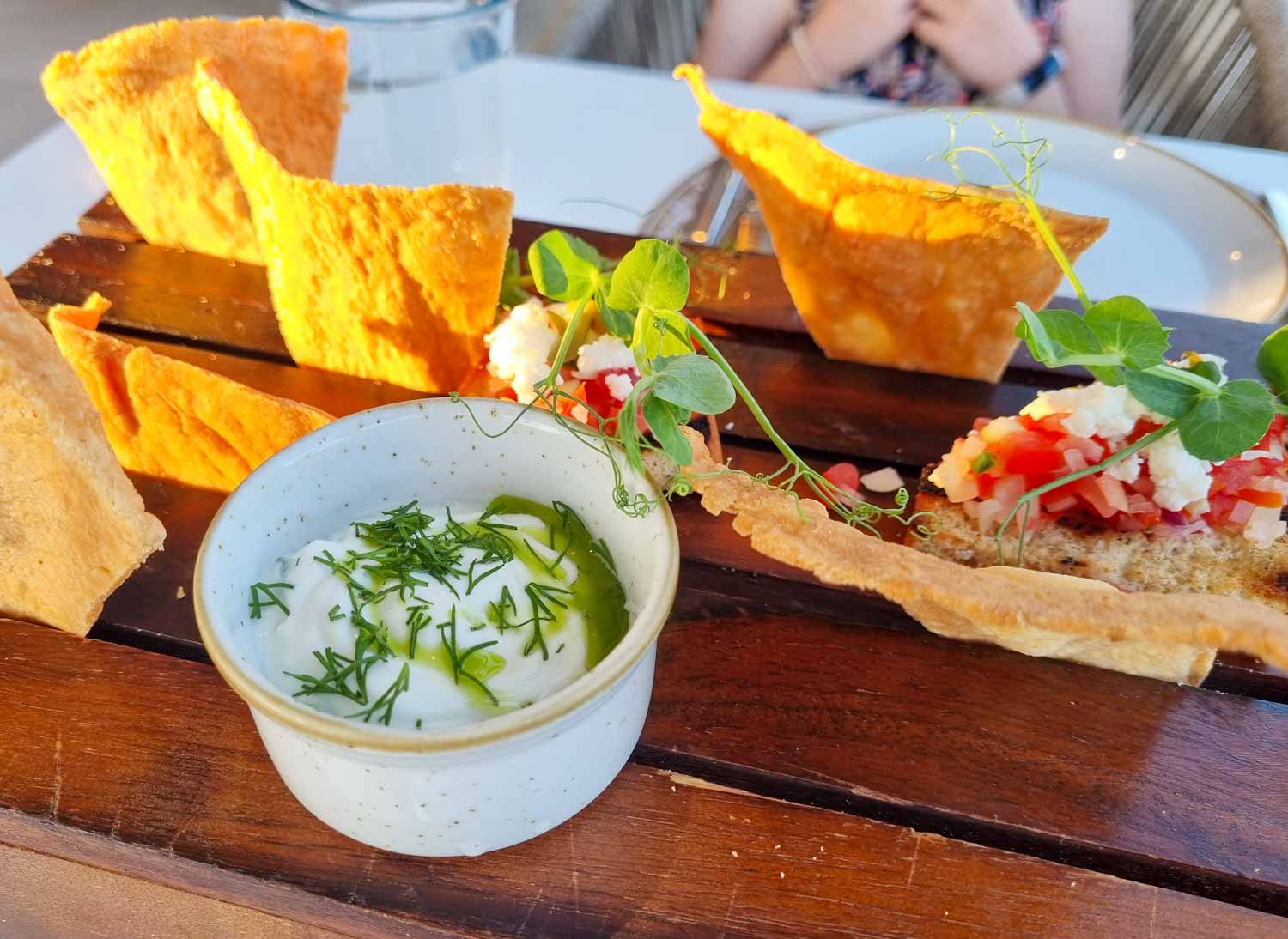 Plate of toasted pitta bread, Greek-style bruschetta and tzatziki on a wooden board at one of the restaurants in Gennadi Grand Resort in Rhodes - my review of the five-star hotel