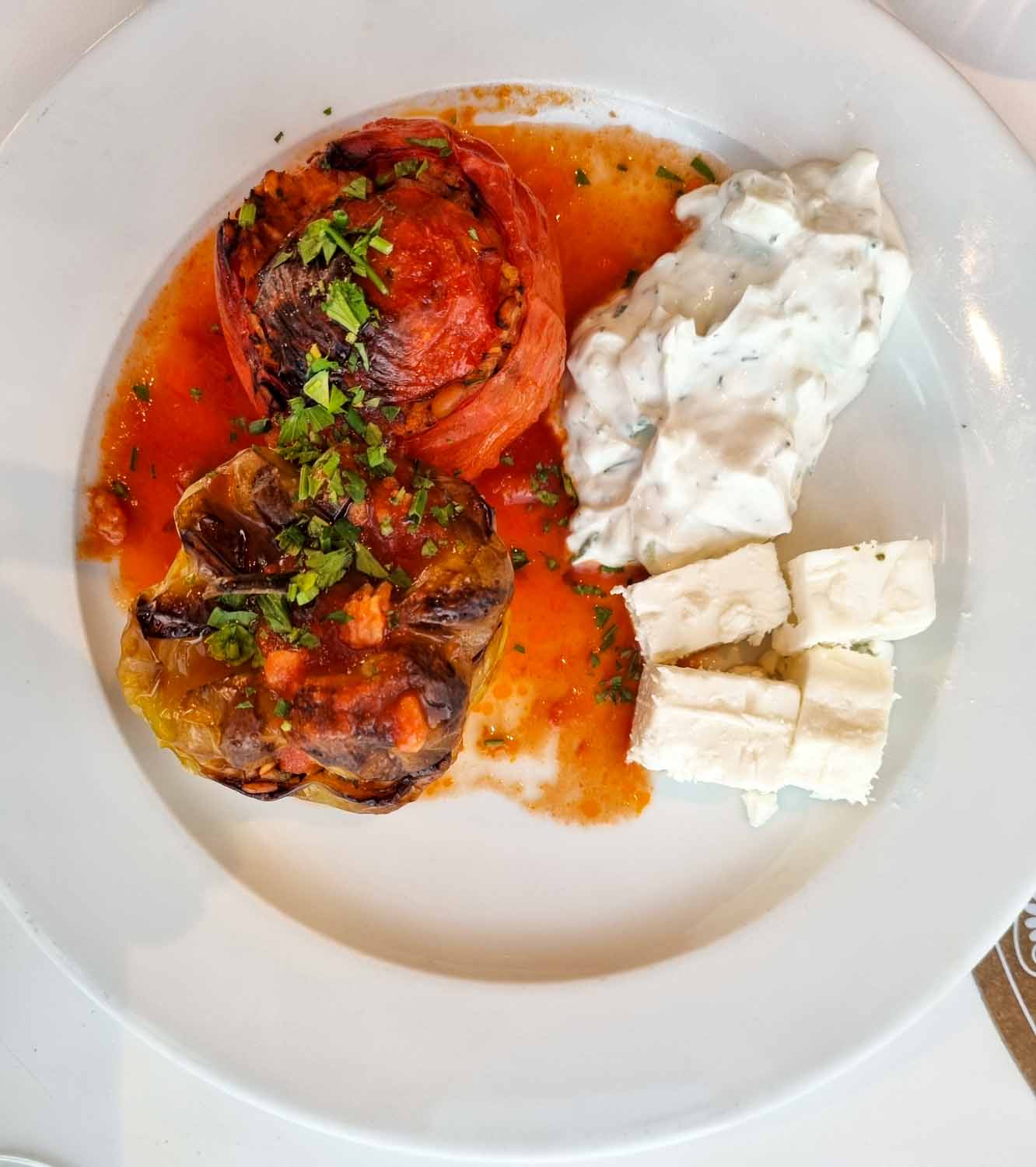Plate of stuffed tomato and peppers with tzatziki and feta - one of the dishes we helped to make in a cooking lesson at Gennadi Grand Resort in Rhodes with kids
