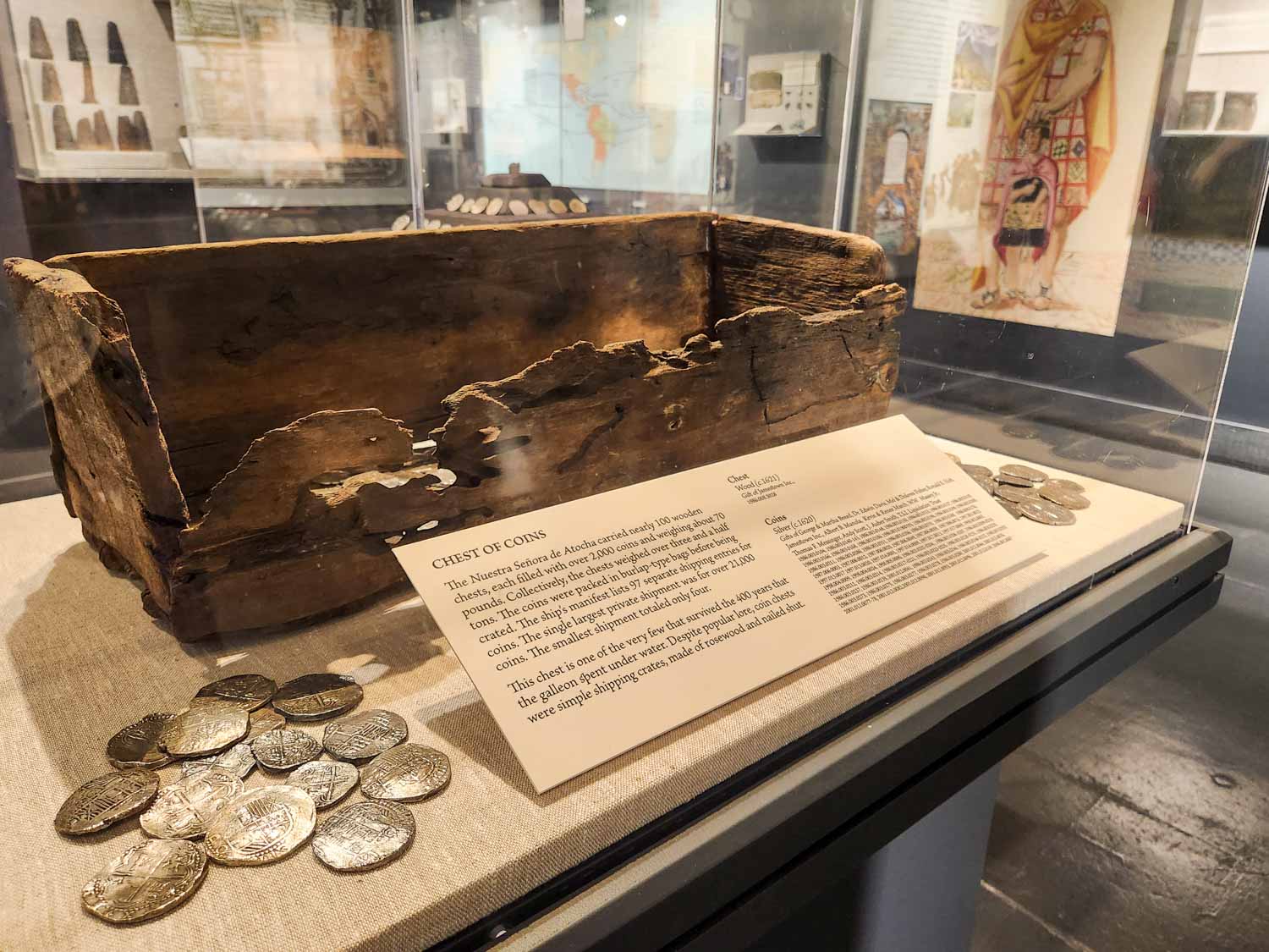 View of a broken wooden chest and coins rescued from the wreck of the Atocha and on display in the Mel Fisher Maritime Museum, one of the best things to add to your Florida Keys itinerary with kids