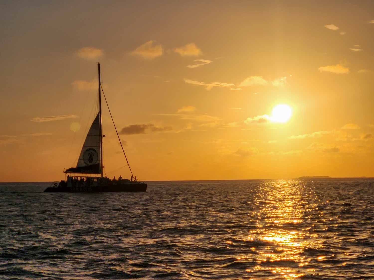 View of a sailing ship silhouetted against the horizon just before sunset - a sunset cruise is one of the best things to do in Key West with older kids during a Florida Keys road trip