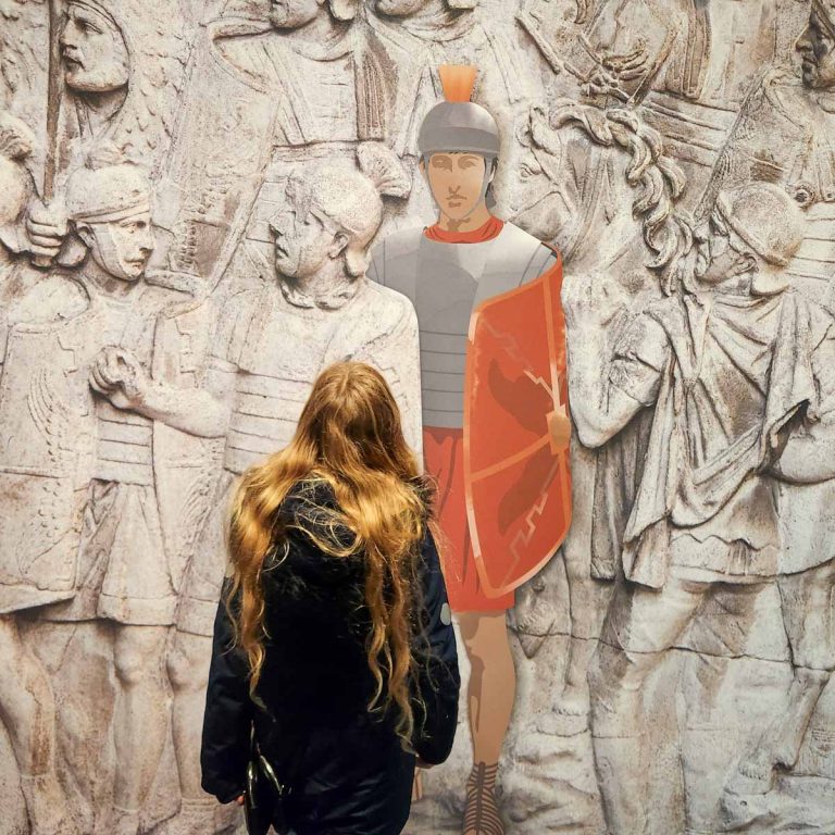 My daughter looks at a colourful figure of a Roman solider in a recreated stone carving at the entrance to the British Museum's new exhibition, Legion: Life in the Roman Army - my Legion exhibition review