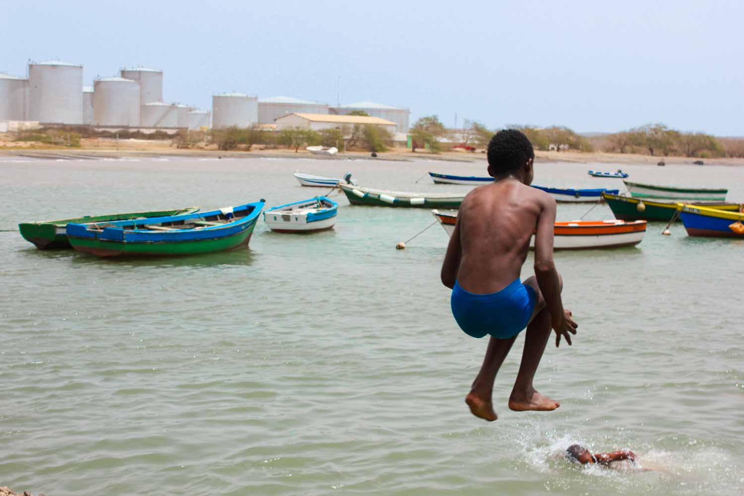 A boy jumping into the harbour at Palmeira in Sal, Cape Verde. So should you visit Cape Verde with kids? My top tips on exploring these family-friendly islands off Africa, especially Sal with kids