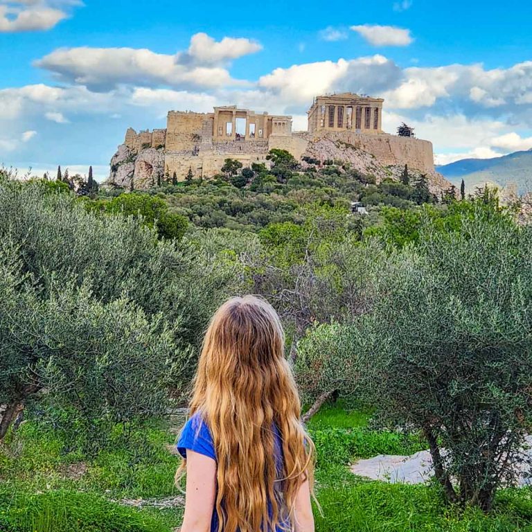 My daughter looks to the Acropolis from Pnyx Hill during a visit to Athens with kids