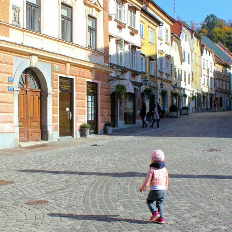 Child running in the pedestrian streets of the Old Town in Ljubljana, Slovenia - discovering Ljubljana with kids