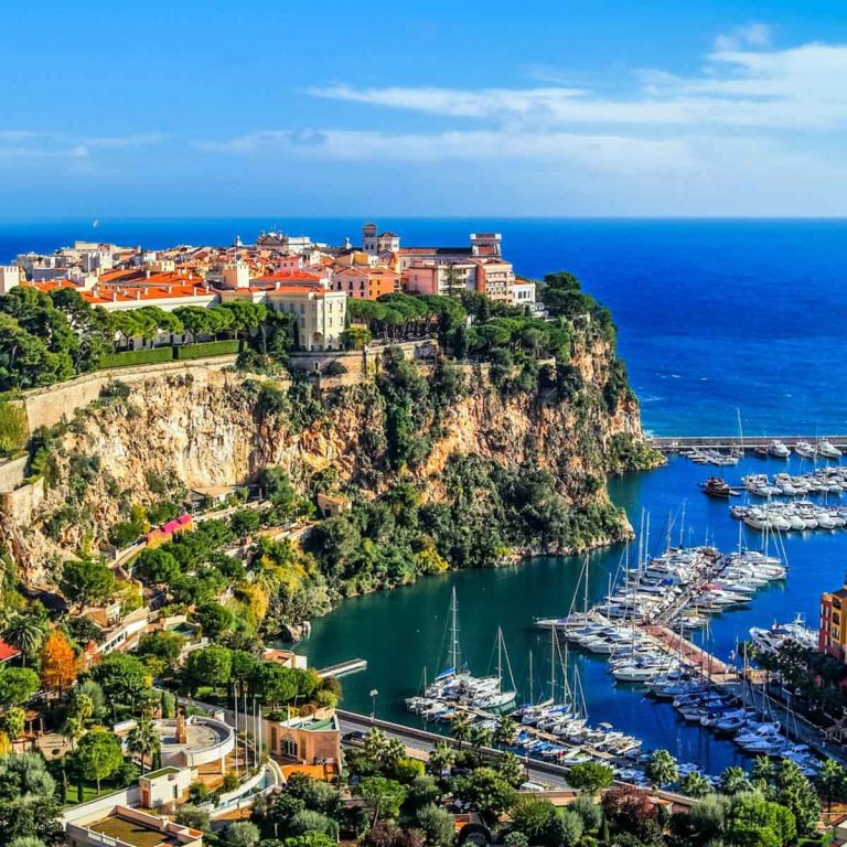 View of buildings on the rock in Monaco and yachts in the harbour below - my tips for visiting Monaco with kids