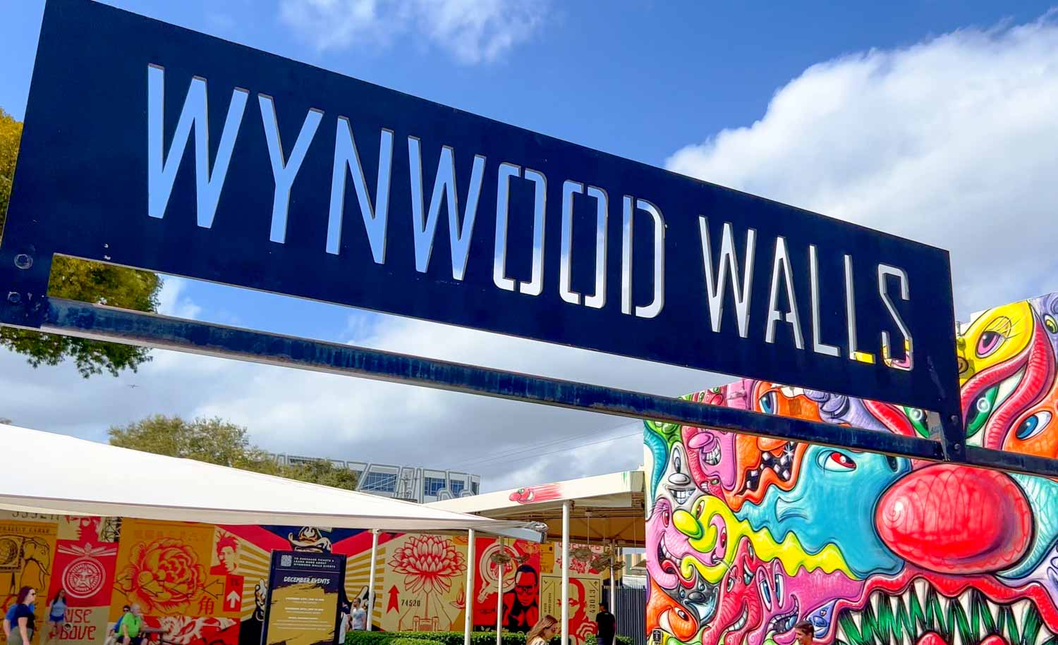 Sign for Wynwood Walls in Miami and some of the murals in the area - a visit here and to the Museum of Graffiti is one of the best things to do in Miami with teens