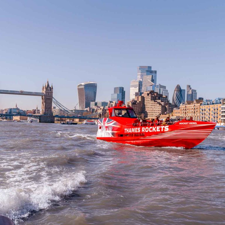 View of bright red Rocket Rebel speedboat on the Thames with Tower Bridge and the skyscapers of the city in the background - my Rocket Rebel review