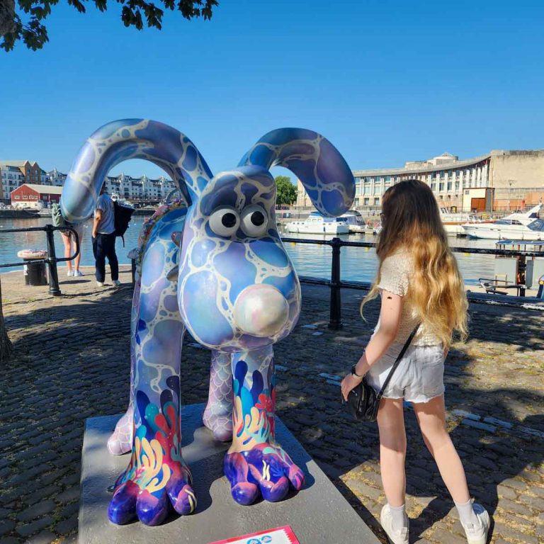 My daughter looks at a sea-themed statue of Gromit by the Harbourfront in Bristol - my Gromit Unleashed 3 review of a visit to Bristol with kids