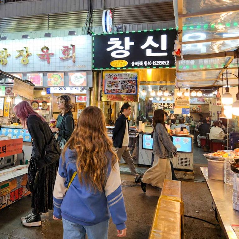 Girl walking past the stalls at Gwangjang Market in Seoul - what to eat in South Korea with kids