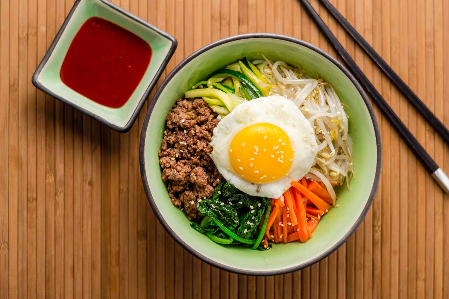 Bibimbap with beef, vegetables and fried egg on top, plus chopsticks - cooking classes are one of the fun things to do in Gyeongju with kids