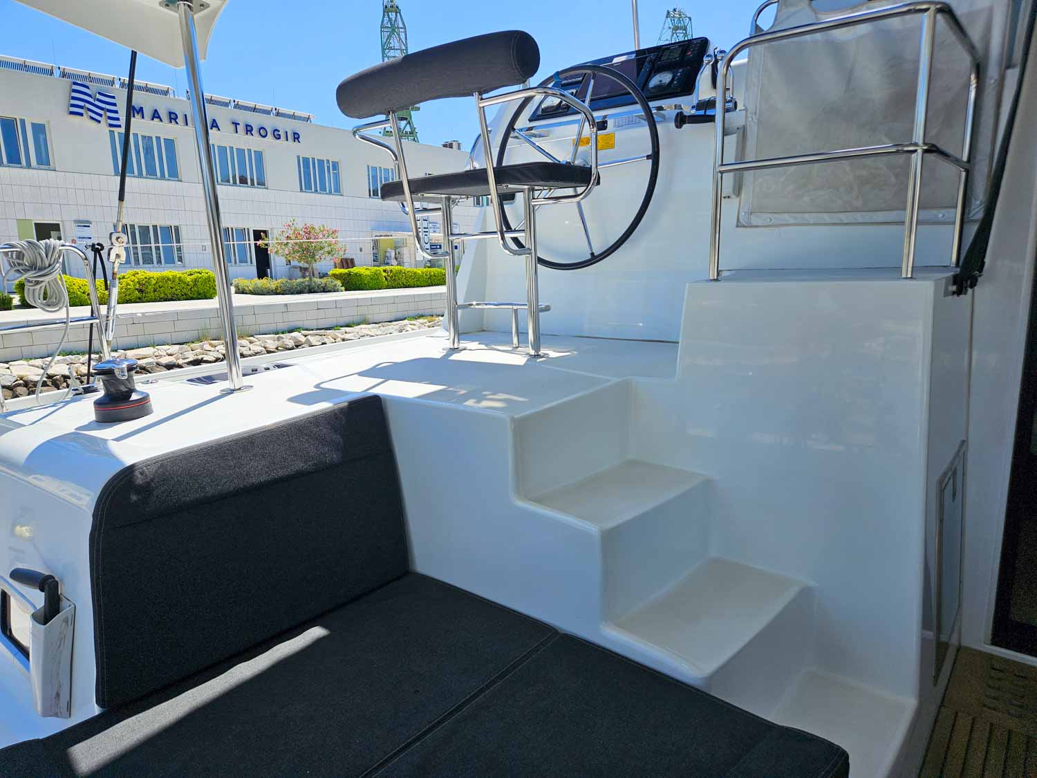 Cushioned shaded seating area at the back of the boat, by steps up to the skipper's chair and controls to drive the boat - my review of a More Sailing Croatia holiday with kids