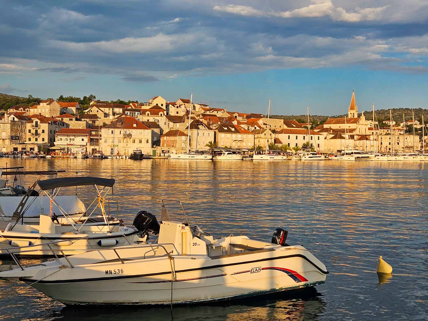 The harbour buildings of Milna on Brac illuminated by the late afternoon sun - the first stop on our Croatia sailing holiday with kids