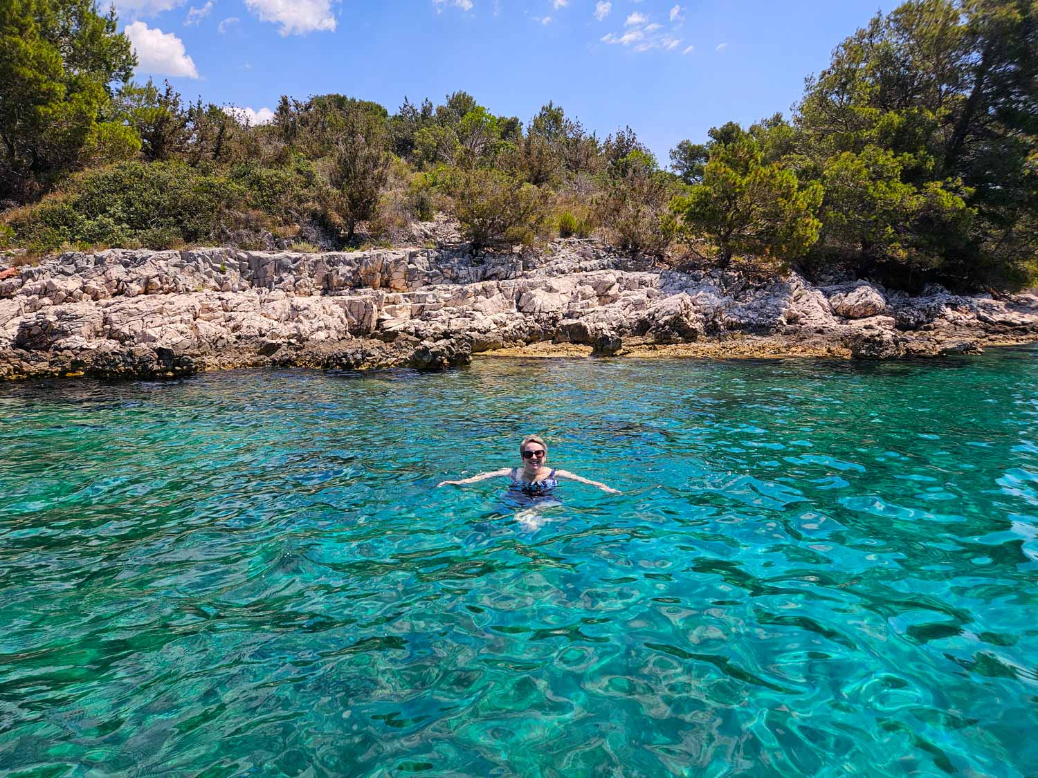 Me swimming in the clear turquoise water of a bay off Hvar during a Croatia sailing holiday with kids