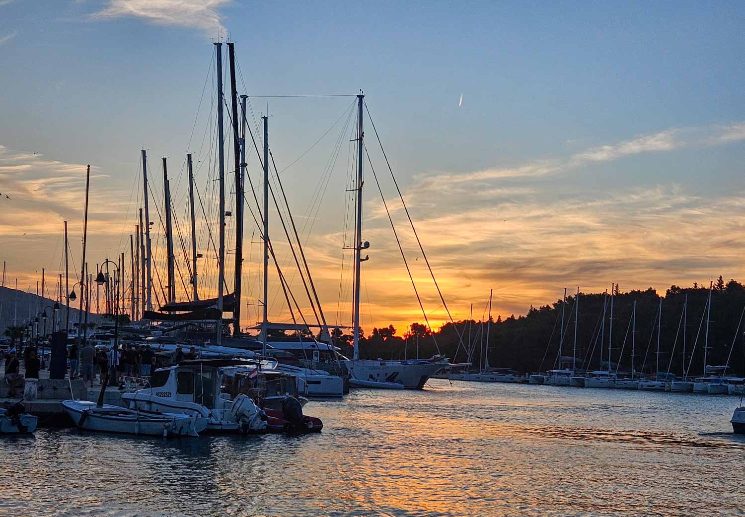Masts of boats silhouetted against the sunset at Stari Grad on Hvar during a Croatia sailing holiday with kids