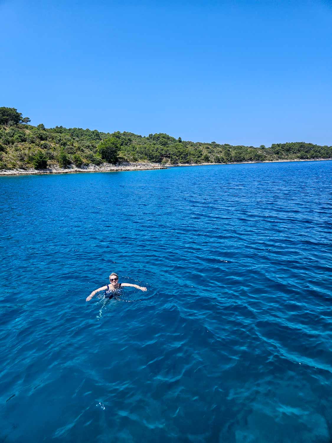Me swimming in dark sapphire waters of the Adriatic during a swim stop by Hvar during a Croatia sailing holiday with kids