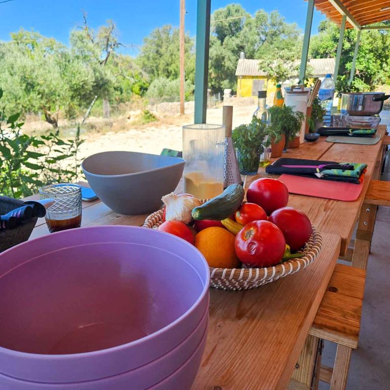 View along the long shady table where we cooked the various dishes, including a bowl of fruits and vegetables - my review of a Kefalonia cooking class with kids