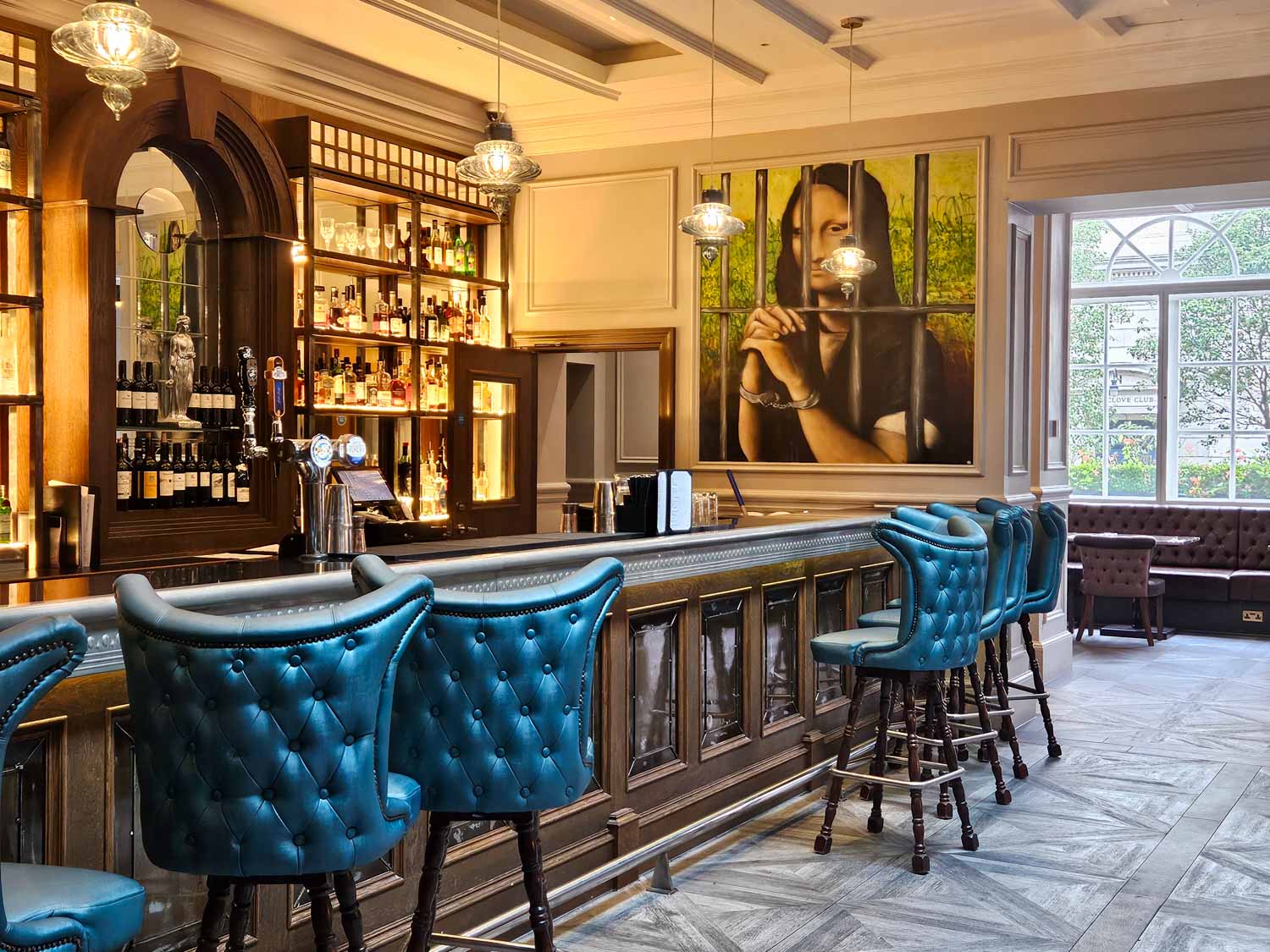 View of the bar at the Jailhouse bar with an image of Mona Lisa in chains - my Courthouse Hotel Shoreditch review