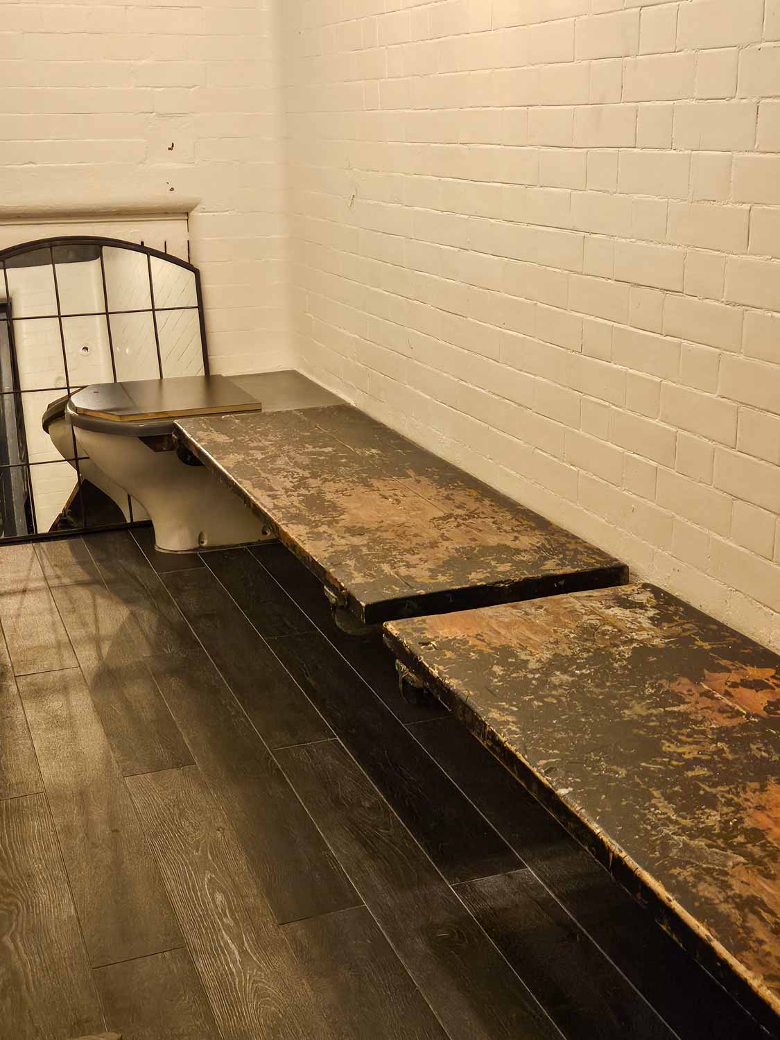 One of the original cells including hard wooden bench and toilet still in the Jailhouse bar - my Courthouse Hotel Shoreditch review