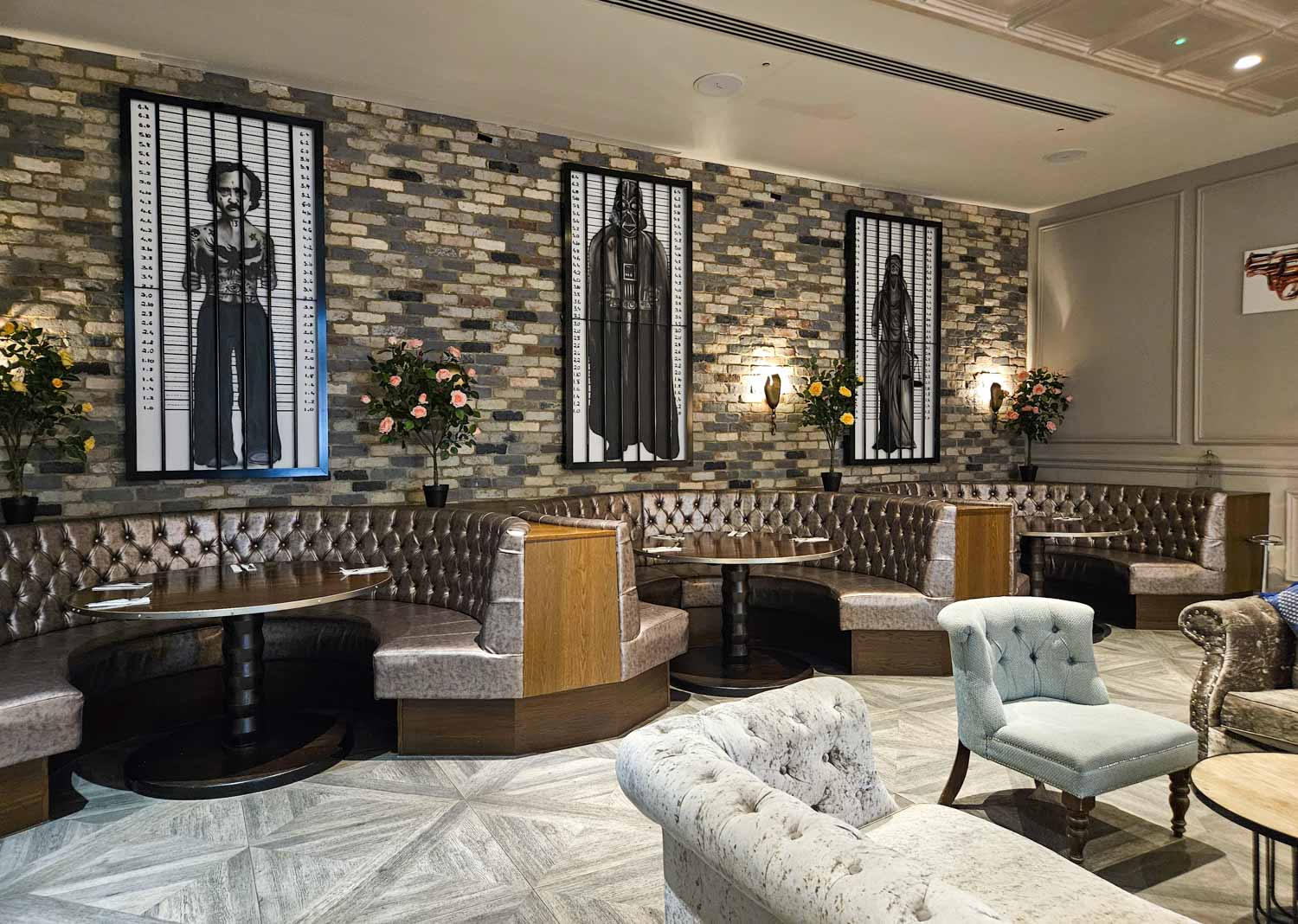 View of some of the booths at the Jailhouse Bar with police height chart mugshots on the wall, including Darth Vader - my Courthouse Hotel Shoreditch review