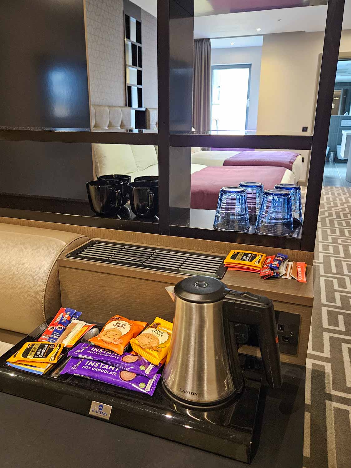 Kettle with tray of tea, coffee and bisctuis, plus cups and mugs and fridge just seen with room behind - my Courthouse Hotel Shoreditch review