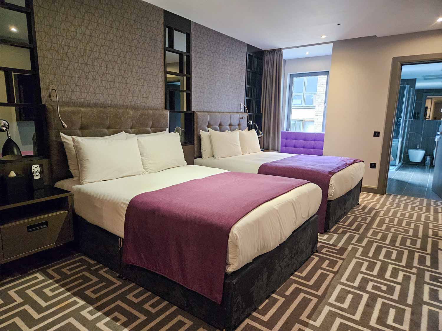 Two double beds with purple accents in the Hoxton family suite with bathroom just seen - my Courthouse Hotel Shoreditch review