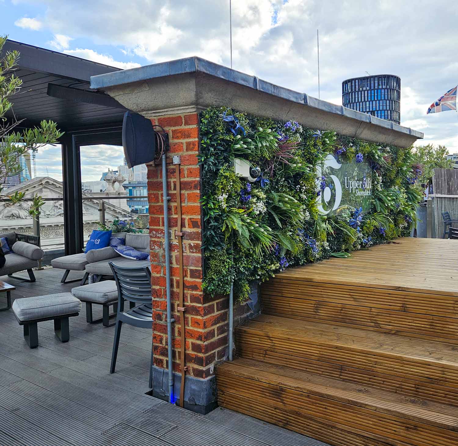 Flower wall and chairs plus buildings just seen on the rooftop terrace - my Courthouse Hotel Shoreditch review