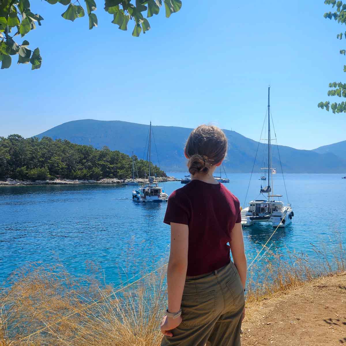 My daughter looks out to some of the yachts and boats moored in the water not far from the harbour - my tips on the best way to spend a day in Fiskardo with kids