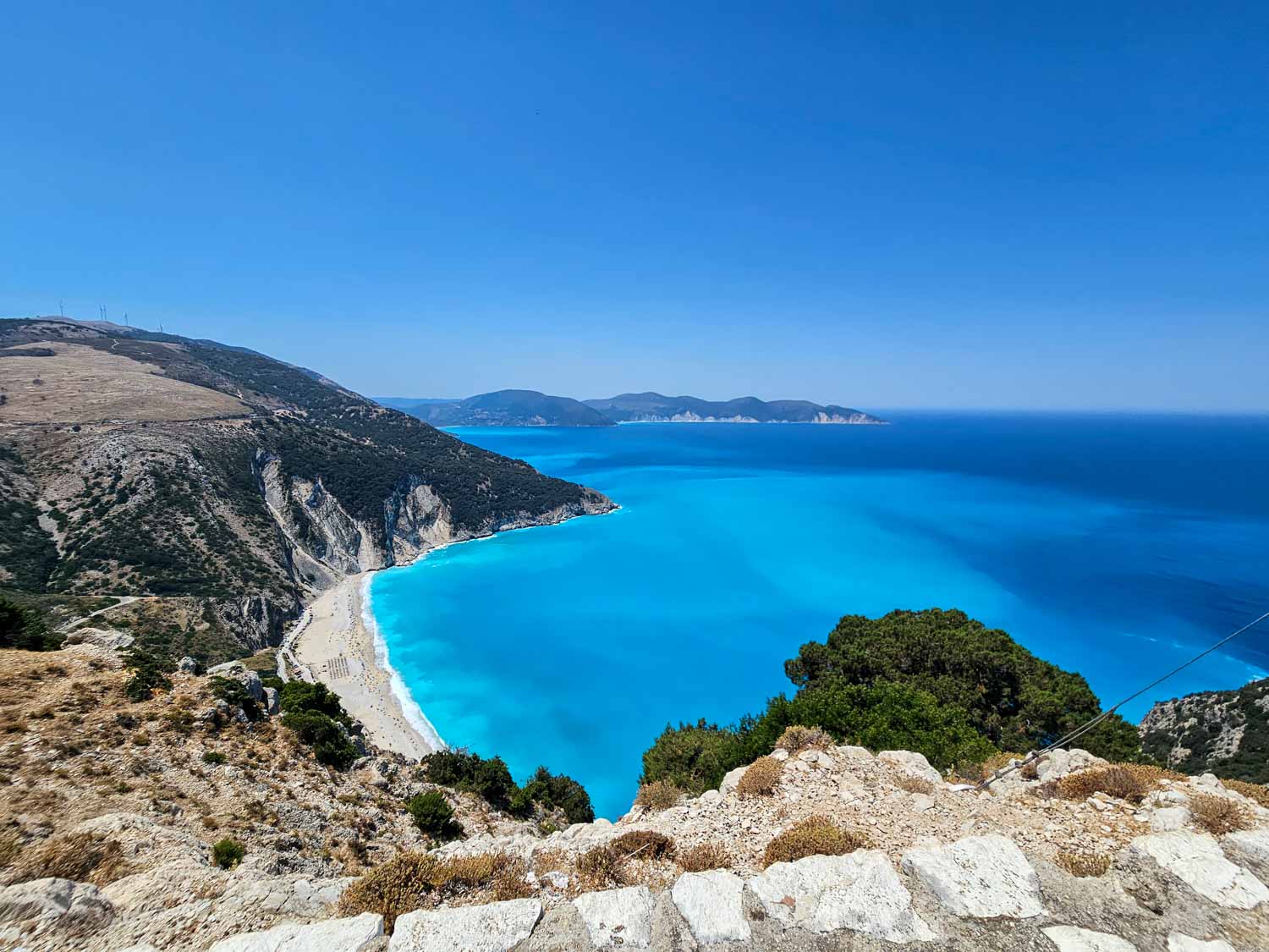 View down onto Myrtos Beach and the blue and turquoise Ionian Sea from a viewpoint on the road between Argostoli and Assos - also a great stopping point if you're spending a day in Fiskardo with kids