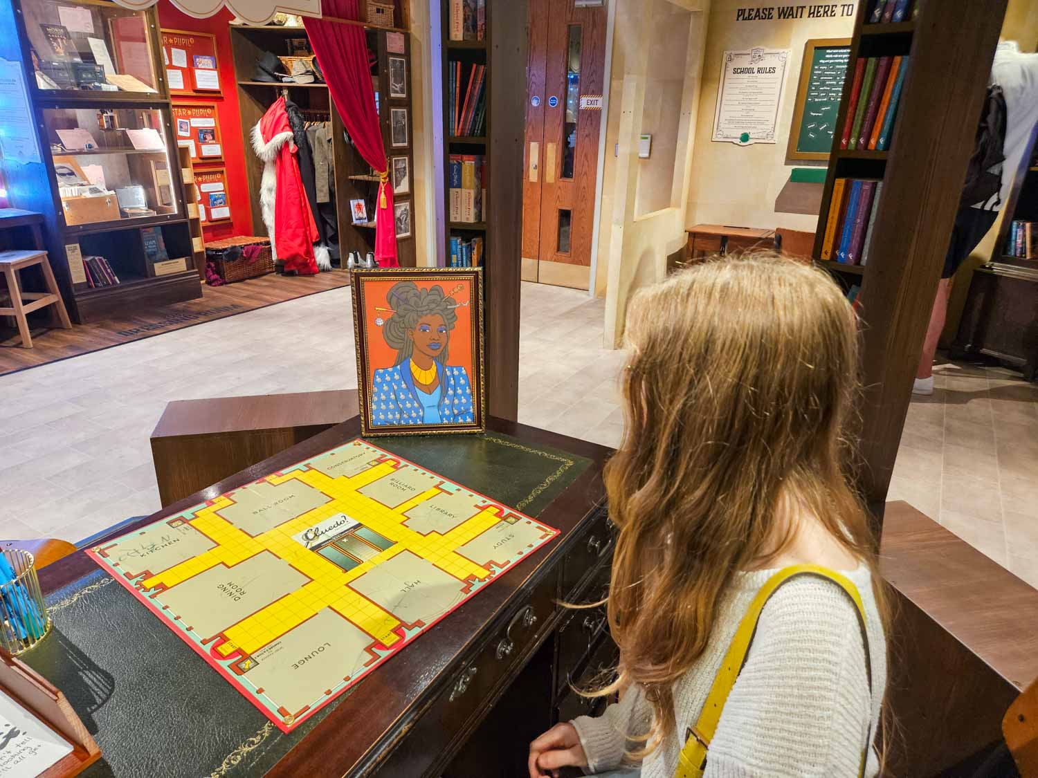 My daughter looks at a Cluedo board and portrait of missing Mystery Academy head teacher at the new exhibition at the Oxford Story Museum - my review