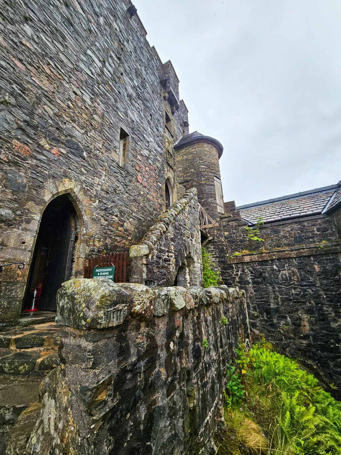 Exterior walls of Eilean Donan castle on a rainy day - a visit is an easy day trip from the Isle of Skye with kids