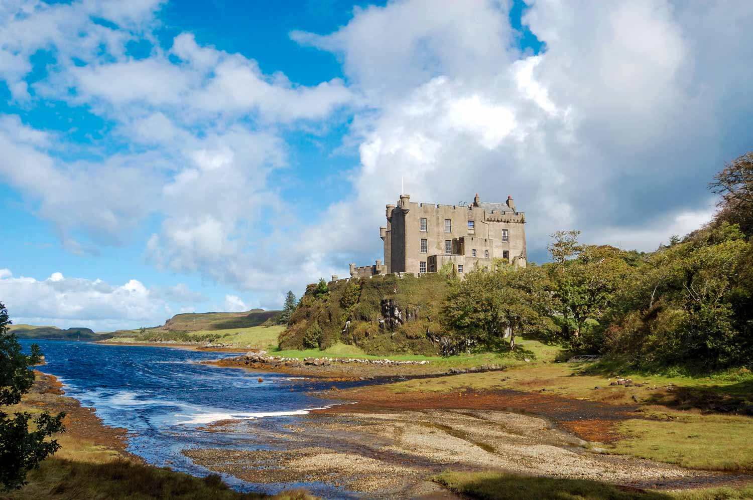View across the water and trees to Dunvegan Castle - one of the historic places to visit in the Isle of Skye with kids